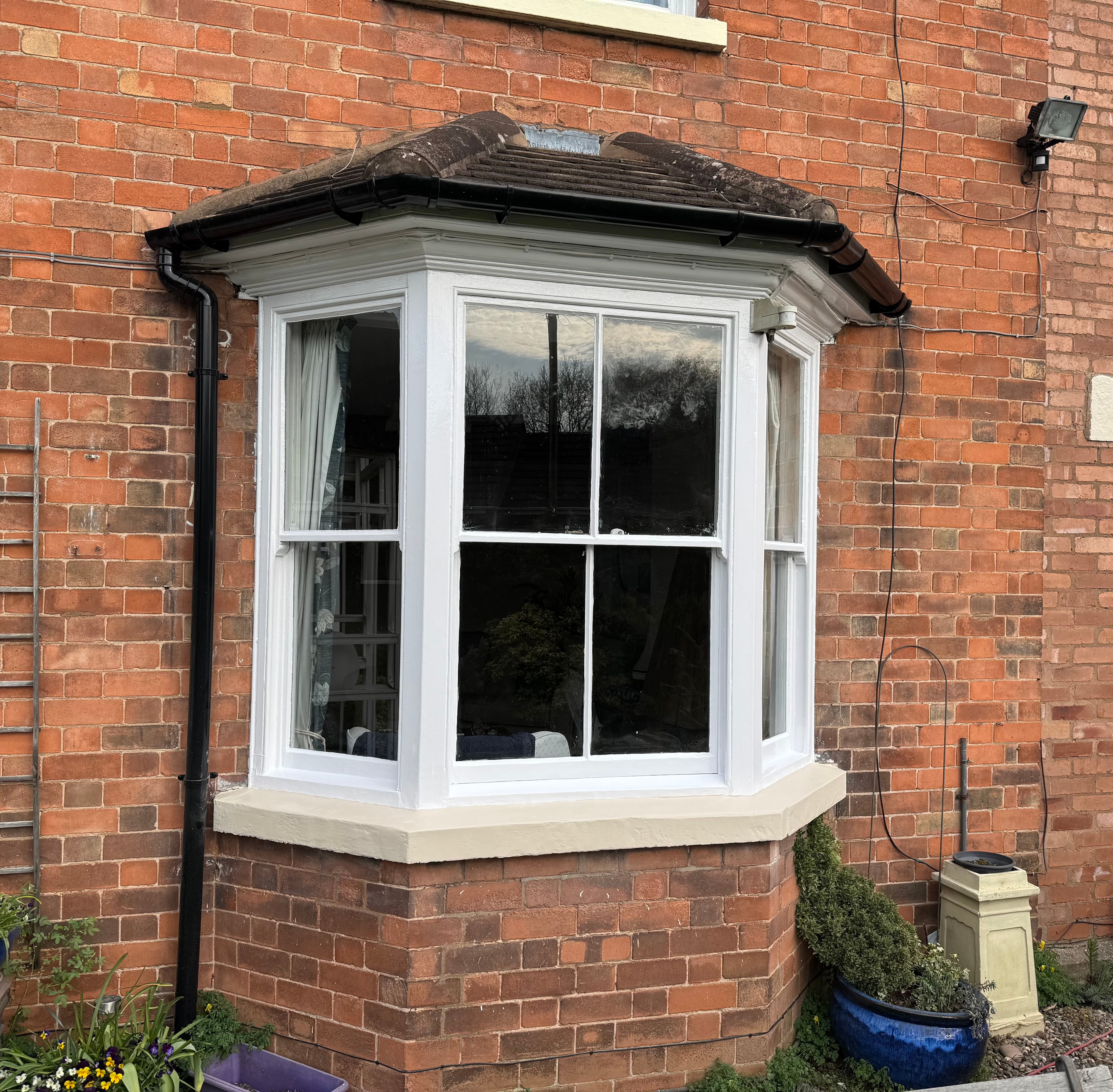 Restored white bay window on Victorian brick property