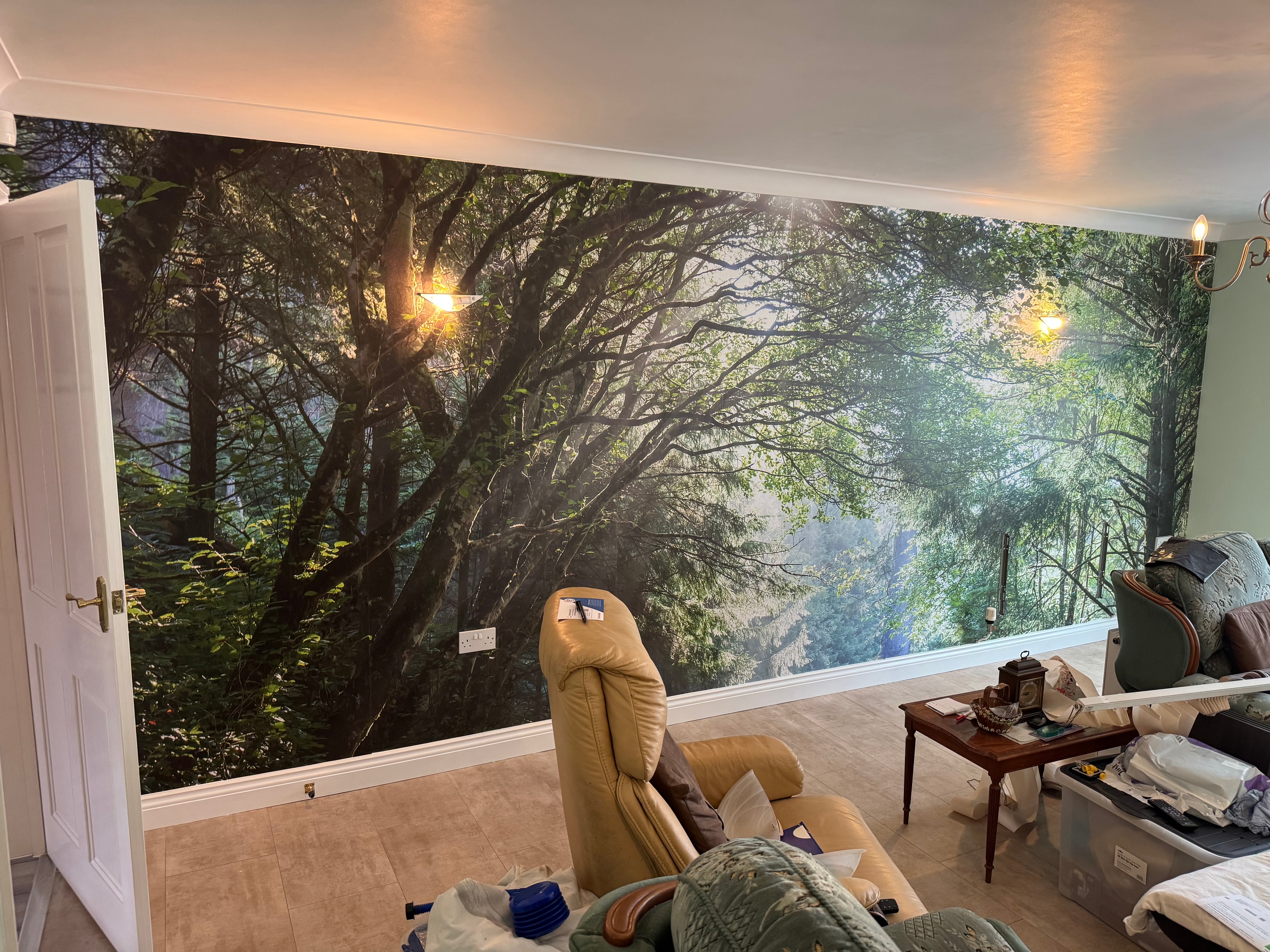 Completed full-wall forest mural wallpaper in living room