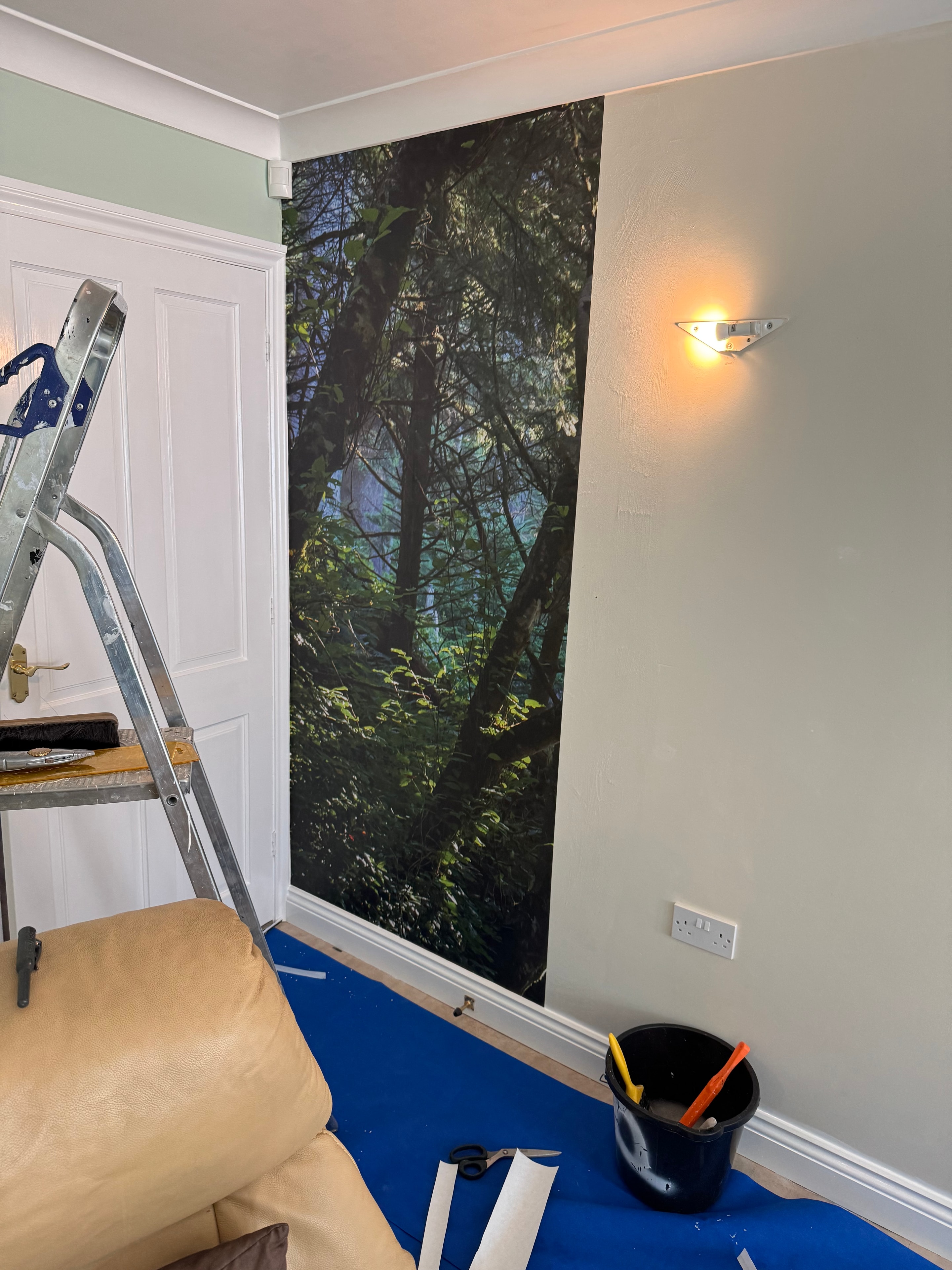 Forest mural wallpaper being hung — in progress