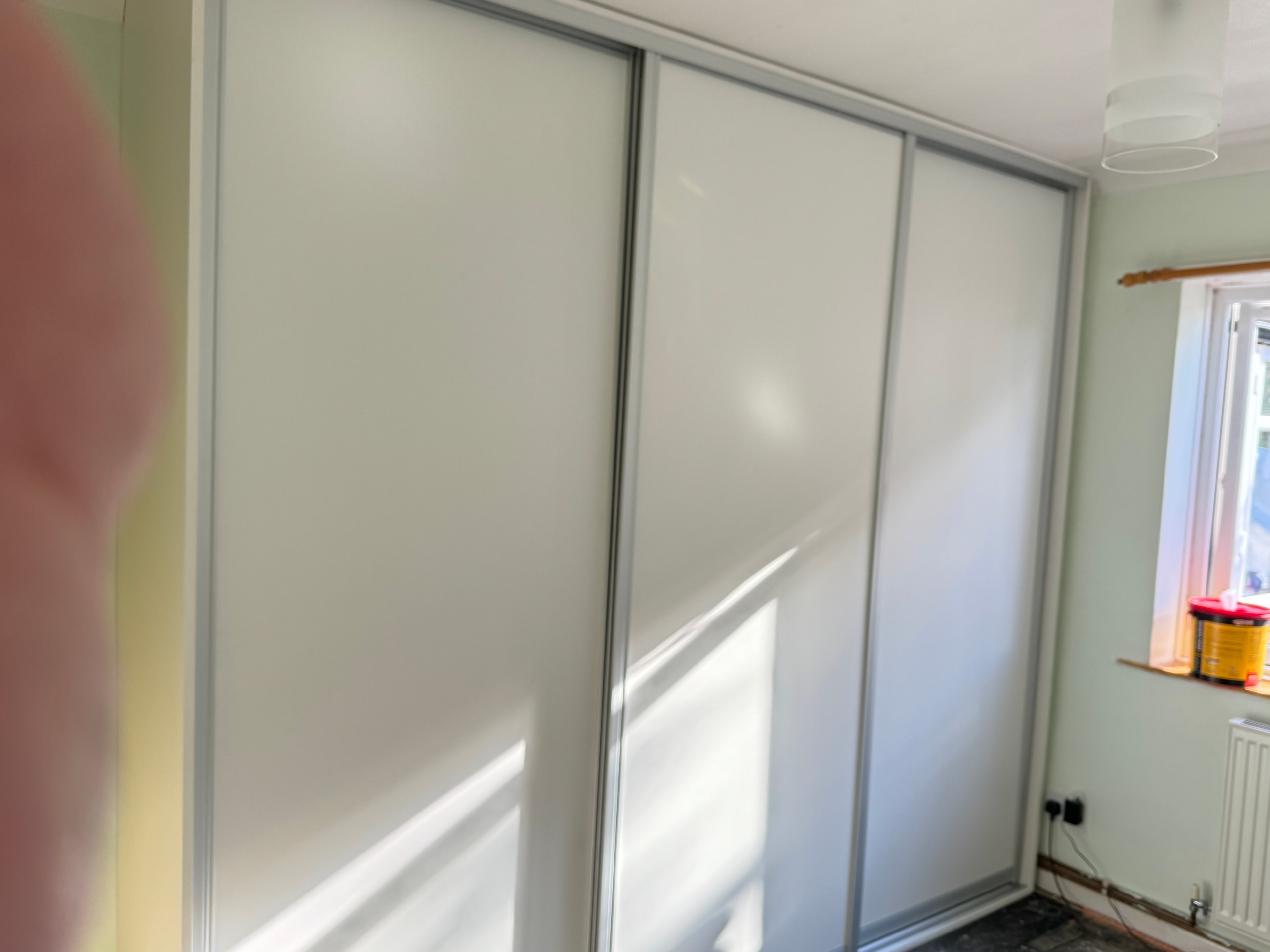 Fitted wardrobe with white sliding doors floor to ceiling